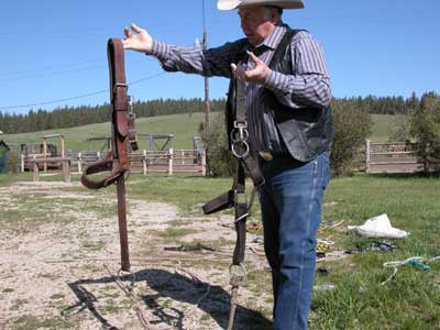Photo of a man displaying a bridle in each hand.